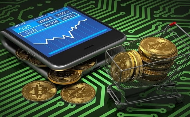 Tiền điện tử Bitcoin trên màn hình thiết bị di động và xe đẩy trên nền mạch điện tử.