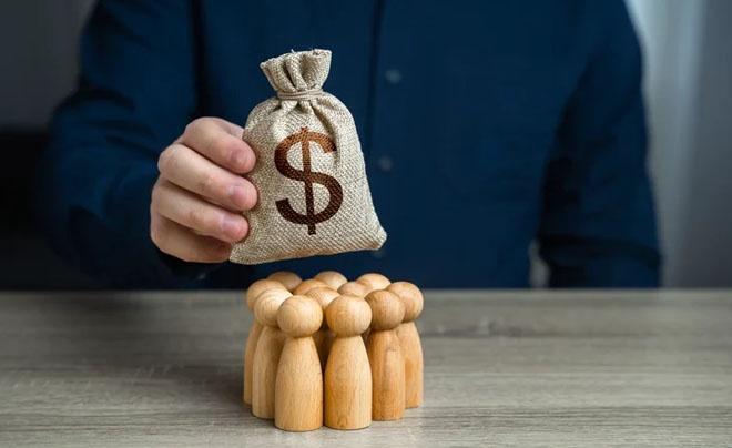 Túi tiền với ký hiệu đô la phía trên nhóm người gỗ.