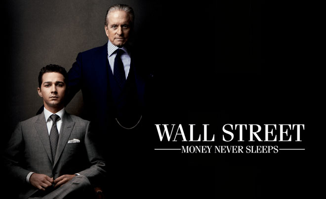 Hai người đàn ông mặc vest đứng cạnh nhau, bên cạnh dòng chữ "Wall Street: Money Never Sleeps".