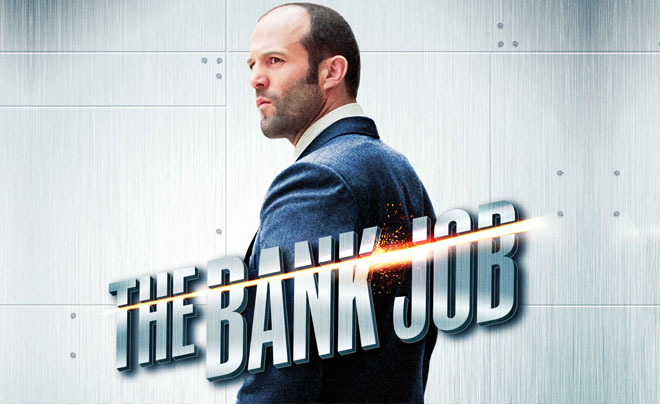 Áp phích phim "The Bank Job" với hình ảnh một người đàn ông đứng nhìn xa, mặc vest xanh, nền kim loại.