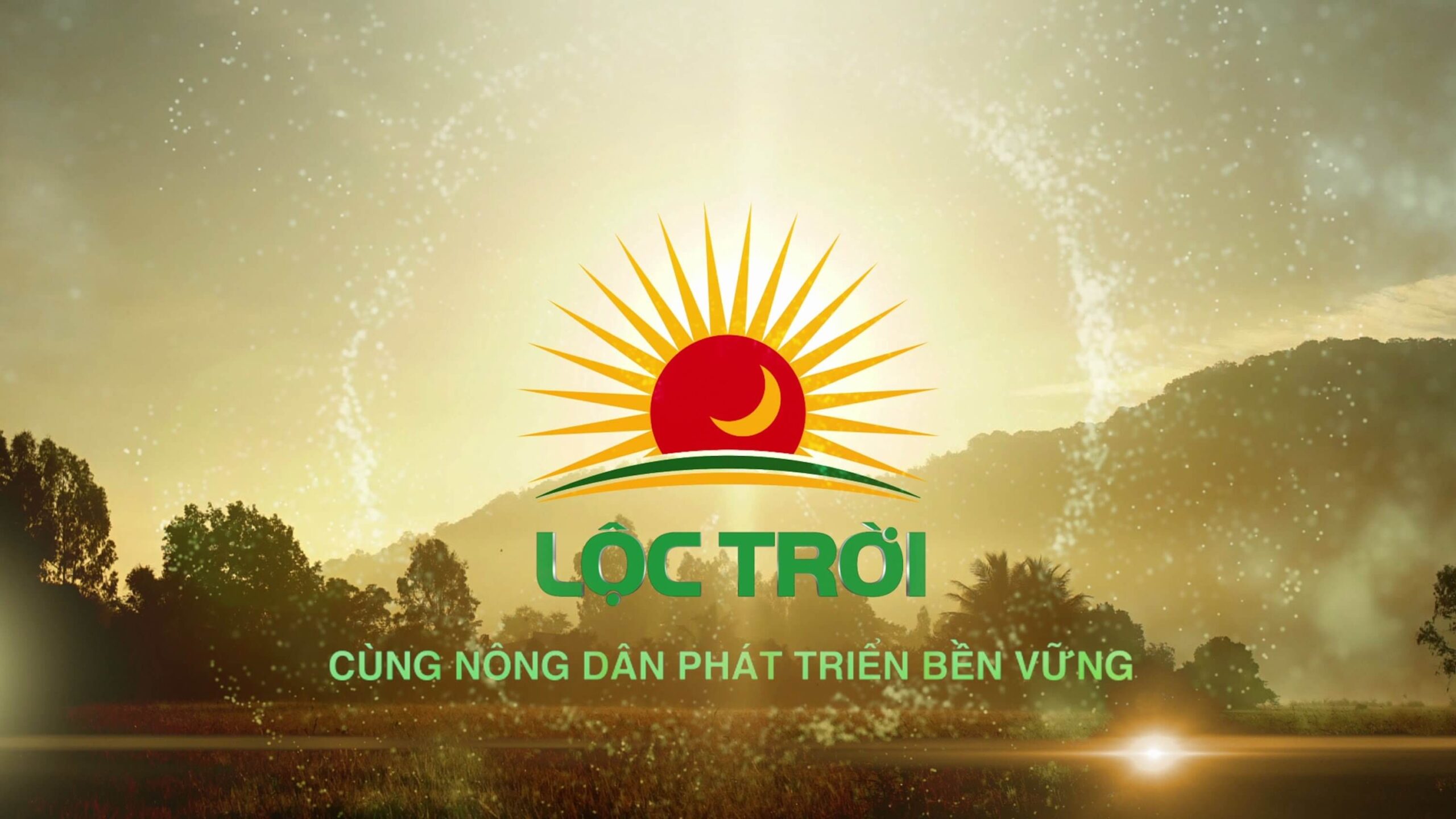 Biểu tượng mặt trời mọc trên nền trời sáng, với hàng chữ và cây xanh phía trước.