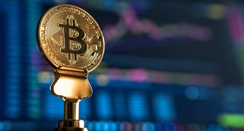 Chiến Lược Đầu Tư Hiệu Quả và An Toàn Với Thu Nhập 10 Triệu 4 Đồng xu biểu tượng Bitcoin trên nền màn hình hiển thị biểu đồ tài chính.