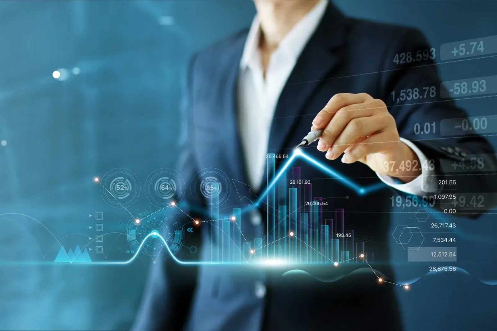 Người cầm b&uacute;t chỉ v&agrave;o biểu đồ t&agrave;i ch&iacute;nh hiển thị c&aacute;c con số v&agrave; xu hướng tr&ecirc;n nền xanh.