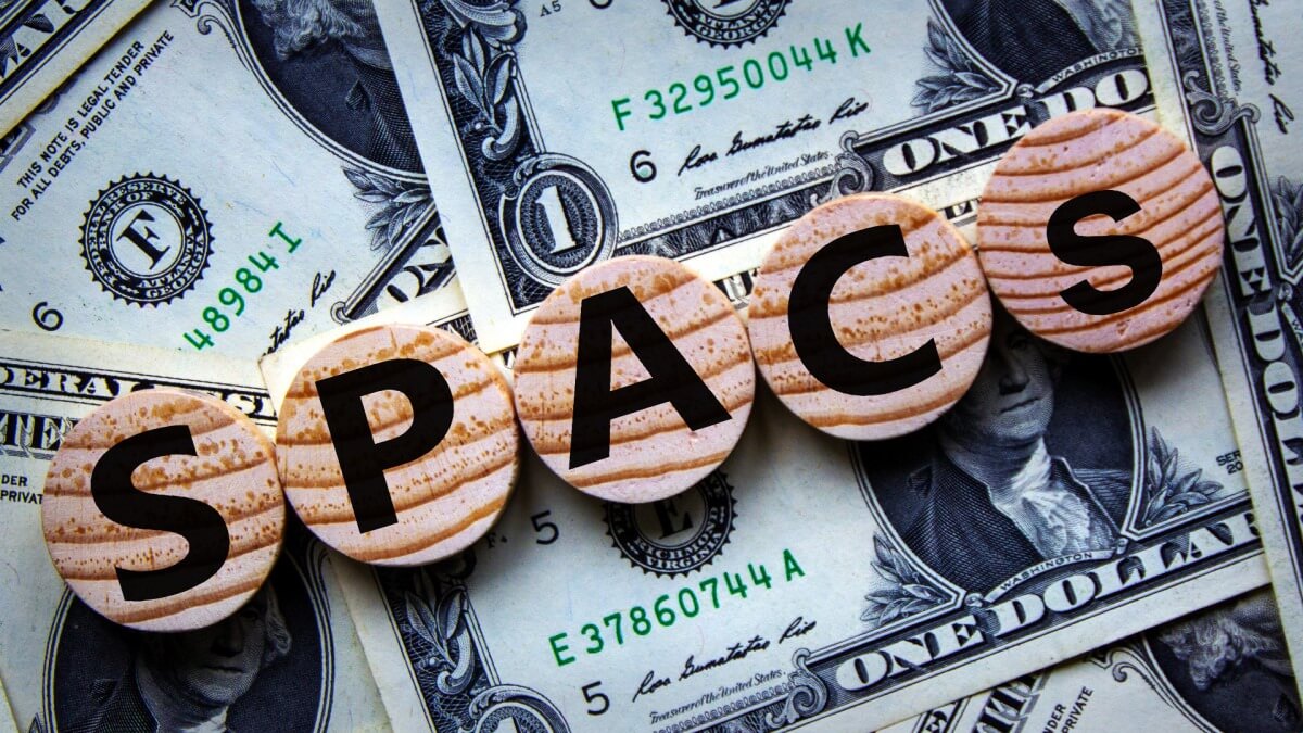 Chữ "SPACS" trên các đĩa gỗ, đặt trên nền tiền đô la Mỹ.