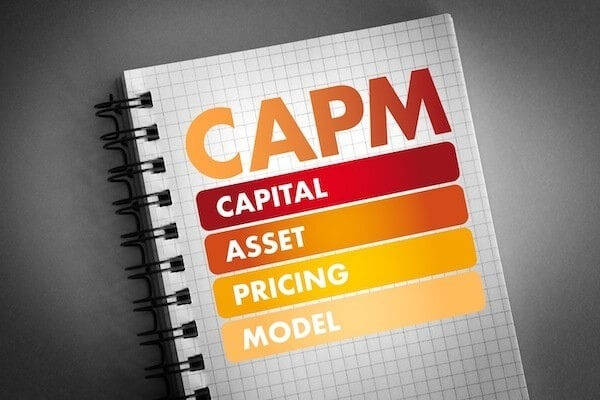 Sổ tay với từ viết tắt CAPM, gồm Capital, Asset, Pricing, Model, trên nền giấy kẻ ô vuông.