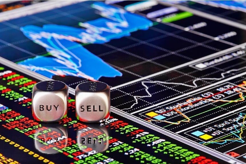 Hai viên xúc xắc với chữ "BUY" và "SELL" trên nền màn hình hiển thị biểu đồ và dữ liệu tài chính.