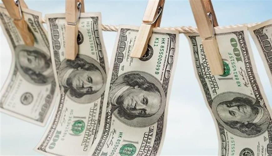 Các tờ tiền đô la Mỹ được kẹp trên dây phơi bằng kẹp gỗ.