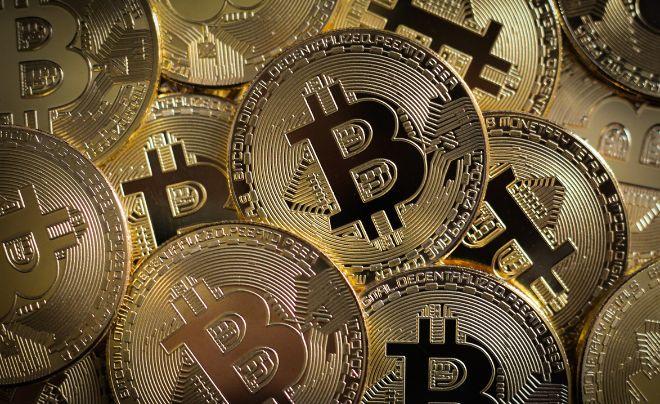 Hình ảnh nhiều đồng xu vàng có biểu tượng Bitcoin xếp chồng lên nhau.