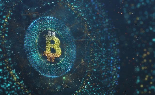 Biểu tượng Bitcoin tỏa sáng trong không gian kỹ thuật số với các điểm sáng màu xanh và vàng.