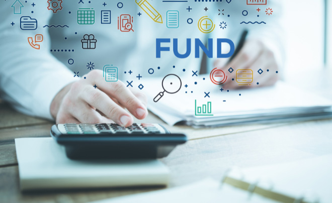 Người đang sử dụng máy tính cầm tay và viết trên sổ, nền có chữ "FUND" và các biểu tượng tài chính.
