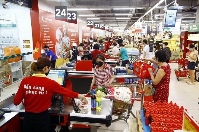 Khách hàng mua sắm và xếp hàng thanh toán tại quầy thu ngân trong một siêu thị đông đúc.