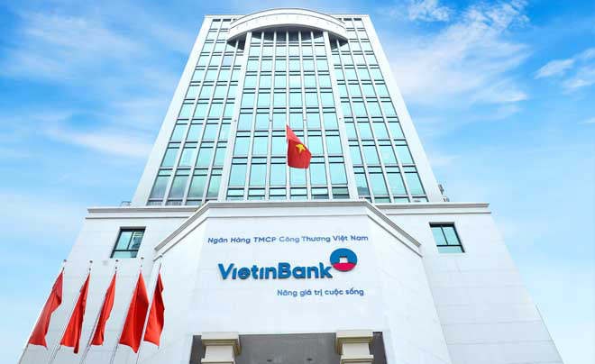 Tòa nhà cao tầng với logo VietinBank, cờ Việt Nam và bầu trời xanh ở phía trên.