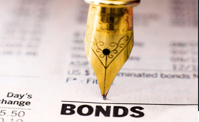 Ngòi bút máy mạ vàng đang chỉ vào từ "BONDS" trên một trang tài liệu tài chính.