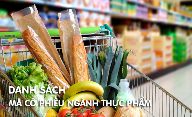 Giỏ hàng trong siêu thị chứa bánh mì, rau củ và hoa quả, phía sau là kệ hàng hóa mờ.