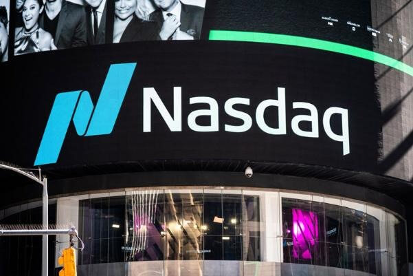 Bảng hiệu Nasdaq trên tòa nhà, phía trên là một màn hình kỹ thuật số hiển thị hình ảnh và văn bản.
