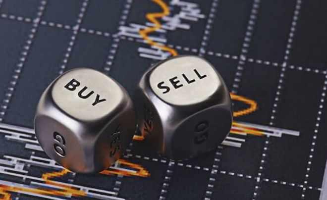 Hai con xúc xắc với chữ "BUY" và "SELL" nằm trên biểu đồ tài chính với đường đồ thị biến động.
