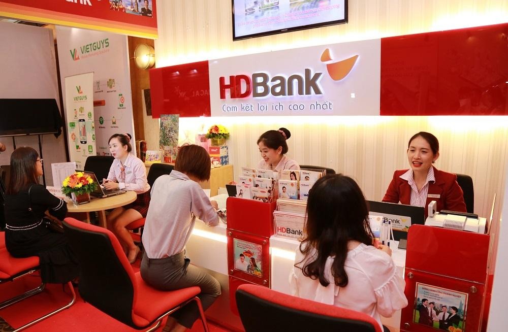 Ngân hàng với nhân viên đang tư vấn khách hàng bên quầy giao dịch, không gian nội thất hiện đại.