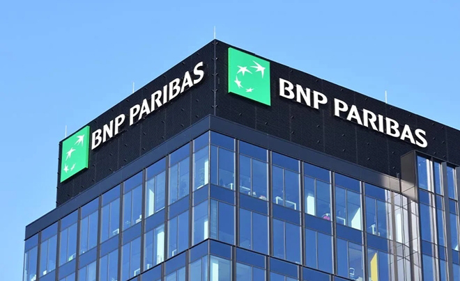 Tòa nhà cao tầng với logo và tên ngân hàng BNP Paribas trên đỉnh, nền trời xanh.