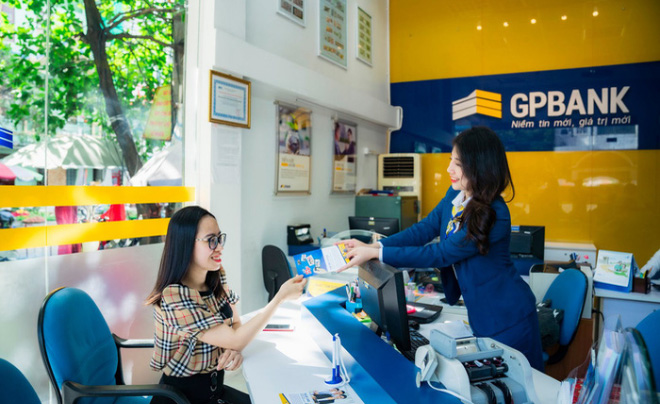 Người phụ nữ nhận tài liệu từ nhân viên tại quầy giao dịch ngân hàng GPBank, không gian sáng sủa và chuyên nghiệp.