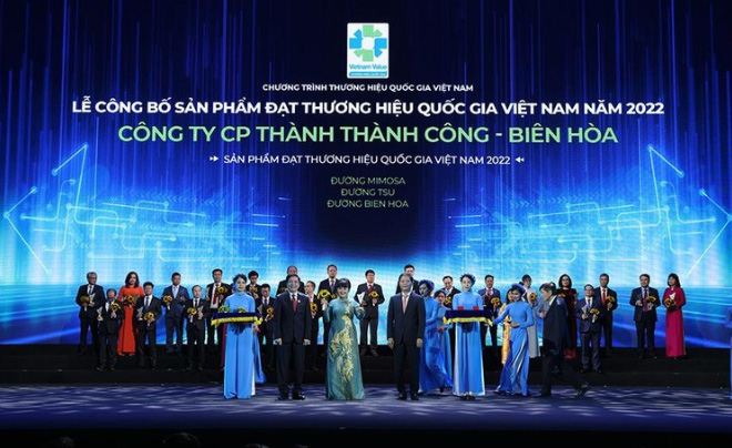 Một nhóm người trên sân khấu trong buổi lễ trao giải thưởng thương hiệu quốc gia, phông nền màu xanh.