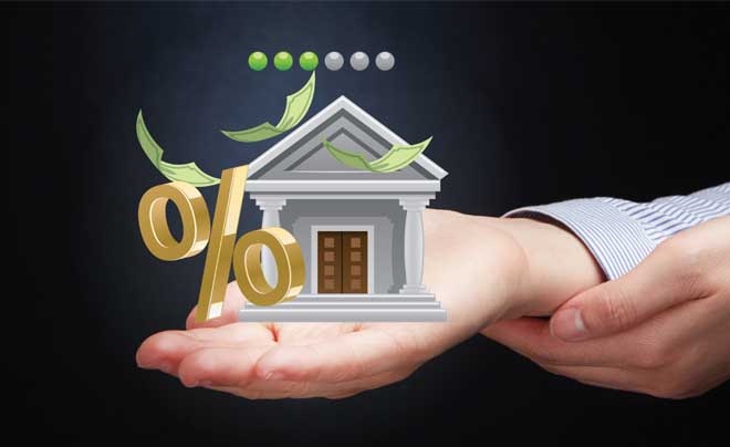 Bàn tay nâng đỡ biểu tượng ngân hàng với ký hiệu phần trăm và tiền bay quanh, trên nền tối.