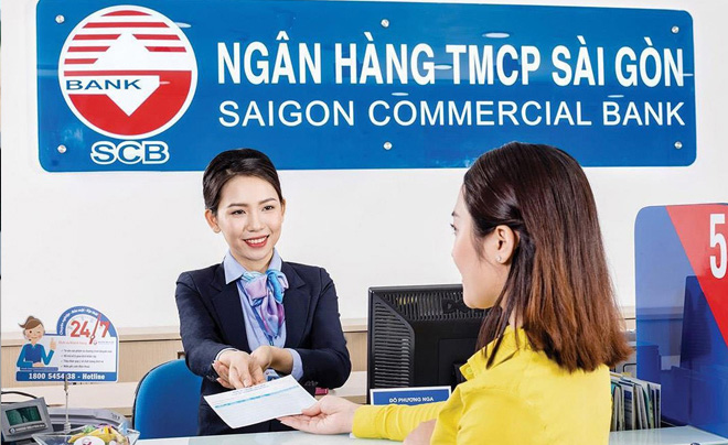 Nhân viên ngân hàng trao đổi tài liệu với khách hàng tại quầy giao dịch của Ngân hàng TMCP Sài Gòn.