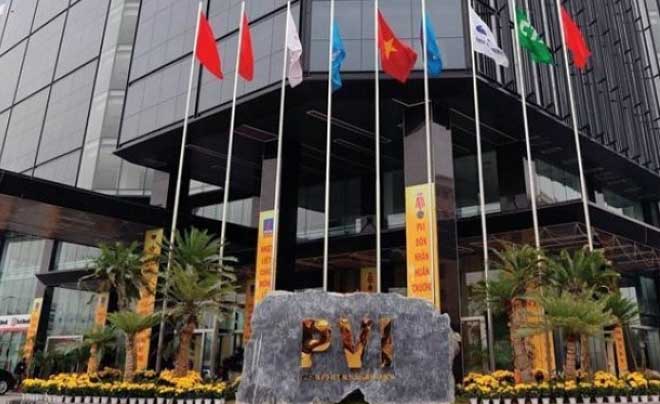 Tòa nhà hiện đại với cột cờ và biểu ngữ, phía trước có một tảng đá khắc chữ PVI.