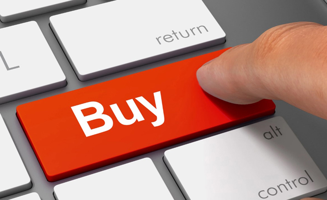 Ngón tay nhấn vào phím "Buy" màu đỏ trên bàn phím máy tính, xung quanh là các phím khác như "return", "alt".