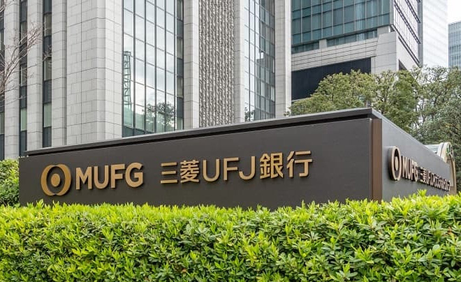 Biển hiệu ngân hàng MUFG với cây xanh phía trước, tòa nhà cao tầng phía sau.