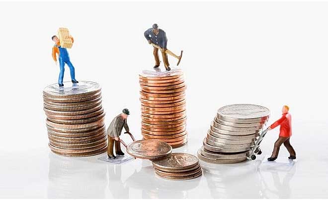 Các mô hình người nhỏ đang làm việc trên các chồng đồng xu, tượng trưng cho công việc và kinh tế.