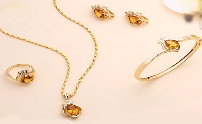 Bộ trang sức vàng gồm nhẫn, vòng đeo tay, dây chuyền và bông tai với đá quý màu cam.